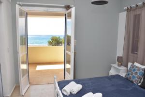 a bedroom with a bed and a view of the ocean at Ammos Apartments in Ierápetra