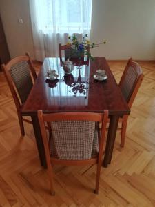 a wooden table with chairs and a wooden floor at Guesthouse "KISTAURI" in Telavi