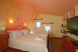 a bedroom with a white bed with a tv at Villa AnnaMaria in Kastéllion