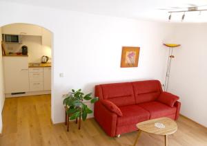un soggiorno con divano rosso e tavolo di Haus Appesbacher a St. Wolfgang