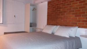 a bedroom with a white bed and white walls at Rio NaturAL in Vila Nova de Milfontes