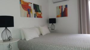 a bedroom with a bed and a lamp at Rio NaturAL in Vila Nova de Milfontes