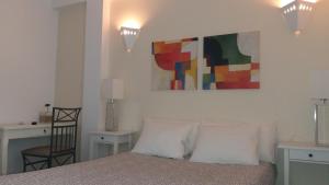 a bedroom with a bed, a lamp and a painting on the wall at Rio NaturAL in Vila Nova de Milfontes