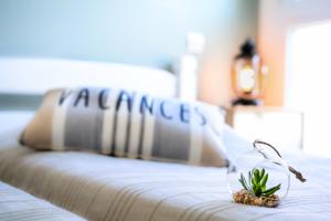 a bed with a pillow with a plant on it at Gîte classé 3 étoiles dans résidence standing avec - Piscine Clim Parking Wifi Prêt Vélos - Ménage et linge non inclus in Saint-Cyprien +24 photos