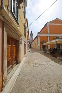 an empty street in an alley with a building at Sites of Zadar Apartments in Zadar