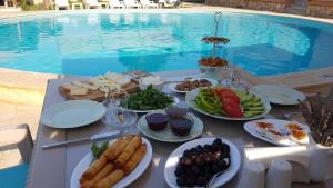 a table with plates of food next to a pool at Princess of Özalp in Dalyan