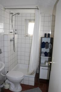 a bathroom with a tub and a toilet and a sink at Kleines, gemütliches Häuschen in Mönchengladbach