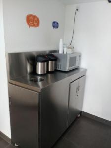 a small kitchen with a counter with a microwave at Hotel Hi ! Torreon Aeropuerto-Galerías in Torreón