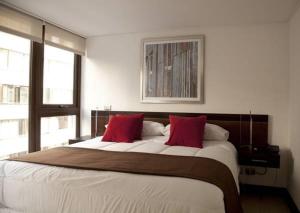 サンティアゴにあるSunset Apartsのベッドルーム1室(大型ベッド1台、赤い枕2つ付)