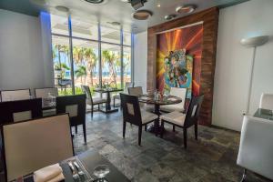 a dining room with tables and chairs and a painting on the wall at San Juan Water & Beach Club Hotel in San Juan