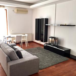 a living room with a couch and a tv and a table at Casa Coquette Buzau in Buzău