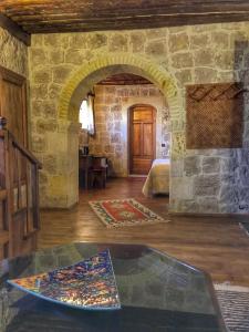 sala de estar con mesa y pared de piedra en Aravan Evi en Urgup