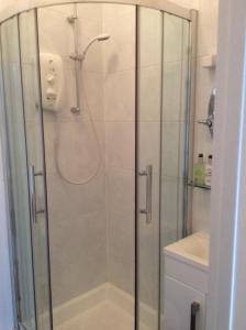 a shower with a glass door in a bathroom at Cheltenham Lawn and Pittvile Gallery in Cheltenham