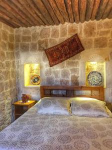 a bedroom with a bed in a stone wall at Aravan Evi in Urgup