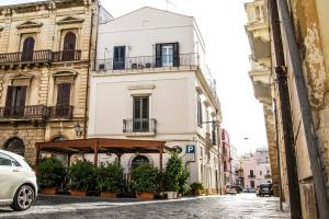 a white building with potted plants on a street at B&B Acquapazza in Brindisi