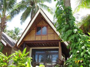 a house in the middle of some palm trees at Latitude 10 Siargao in General Luna