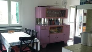 einen rosa Schrank in einer Küche mit einem Tisch in der Unterkunft The Palm House in Santa Margherita Ligure