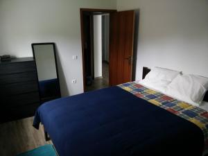 a bedroom with a bed and a dresser and a mirror at Casa da Avó Arminda in Cantanhede