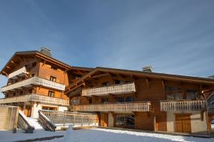 um grande edifício de madeira com varandas na neve em Aiglon Morzine em Morzine