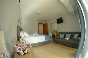 a bedroom with a bed and a couch at The L Studio in Nea Peramos