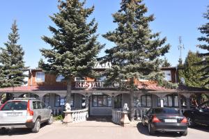 dwa samochody zaparkowane na parkingu przed restauracją w obiekcie Zajazd pod Lwem w mieście Trzebnica