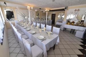 a long table with white tables and white chairs at Zajazd pod Lwem in Trzebnica