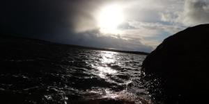 a boat in the water with the sun in the sky at Pensión El abuelo in Carbellino