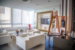 een woonkamer met witte meubels en een televisie bij Hotel Le Cinéma in Gatteo a Mare