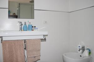 a white bathroom with a sink and a toilet at Casa di Martina in Porto Santo Stefano