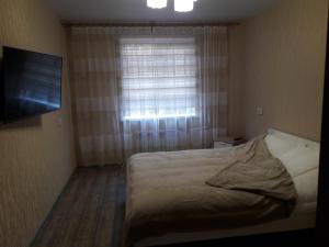 ハバロフスクにあるАпартаменты с 2-мя спальными и гостинной на Ким Ю Чена 9аの小さなベッドルーム(ベッド1台、窓付)
