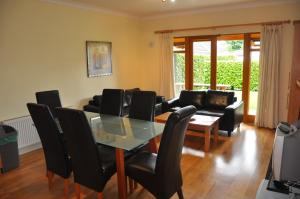 een eetkamer met een glazen tafel en zwarte stoelen bij Heyward Mews Holiday Homes No 2 in Swords