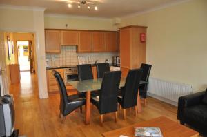 cocina y comedor con mesa y sillas en Heyward Mews Holiday Homes No 2, en Swords