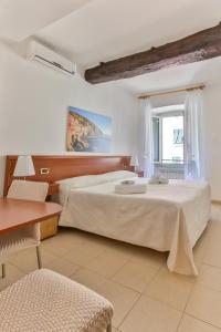 a hotel room with a bed and a desk at Affittacamere Anna Michielini in Riomaggiore