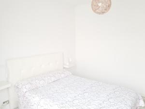 a white bedroom with a bed in a room at Apartamento Playa Agaete in Agaete