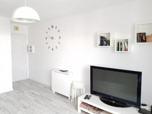 sala de estar con TV y reloj en la pared en Apartamento Playa Agaete, en Agaete