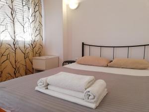 ein Schlafzimmer mit einem Bett mit Handtüchern darauf in der Unterkunft Sfiggos 54 Guest House in Athen