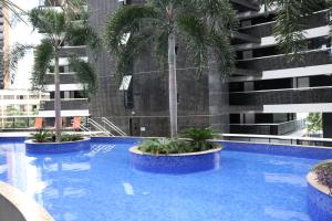 a swimming pool with palm trees in front of a building at Landscape Beira-Mar Perfect in Fortaleza