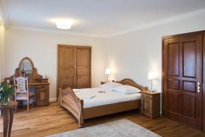 a bedroom with a bed and a dresser and a mirror at Agropark - Dworek pod Lipą in Sobków