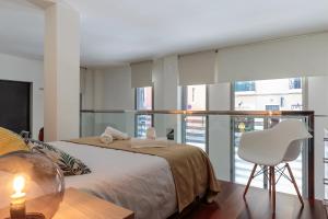 ein Schlafzimmer mit einem Bett, einem Tisch und einem Stuhl in der Unterkunft Modern and Trendy Duplex next to Paseo de Gracia in Barcelona