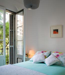 een slaapkamer met een blauw bed en een raam bij Cozy Flat With Unbeatable Views to Sagrada Familia in Barcelona