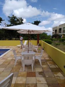 a table and chairs with an umbrella next to a pool at flat em serra negra - bezerros in Bezerros