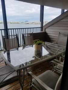 Un balcón con sillas y una mesa de cristal con una planta. en Bahama Princess Condos en Ocean City