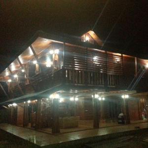 Ban Buak Khang的住宿－Huanmaisakngam Resort，一座晚上带阳台的建筑,灯光照亮
