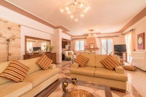 a living room with two couches and a dining room at Fontana Holiday Home in Mouzákion