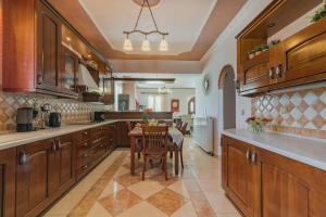 a large kitchen with wooden cabinets and a table at Fontana Holiday Home in Mouzákion