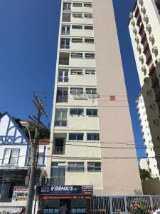 un edificio blanco alto en una calle de la ciudad en Apartamento Napoli, en Salvador
