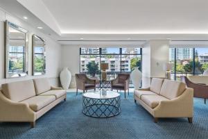 a living room filled with furniture and a large window at Central Dockside Apartment Hotel in Brisbane
