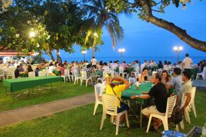 un grupo de personas sentadas en mesas en la playa en Sailom Hotel Hua Hin - SHA Extra Plus en Hua Hin