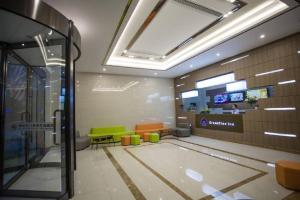 a lobby of a building with tables and chairs at GreenTree Inn Jiangsu Taizhou Dongfeng Road Express Hotel in Taizhou