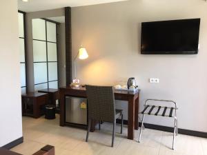 a room with a desk and a television on a wall at Hotel Colibri in Koné